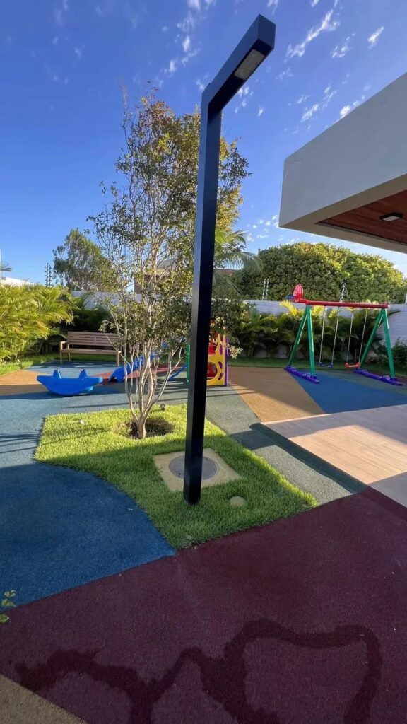 Playground em área externa com piso monolítico de borracha colorido da Pisoleve no condomínio Garden Village em Aracaju, Sergipe.