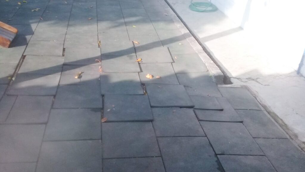 piso de borracha em área externa com falhas e desníveis, exemplo de baixa durabilidade e escolha inadequada de material